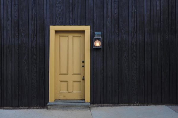 yellow front door on black house